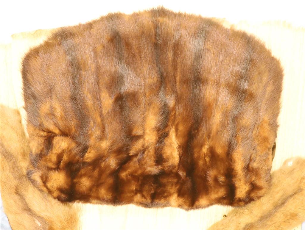 A brown fur muff and a white fur stole